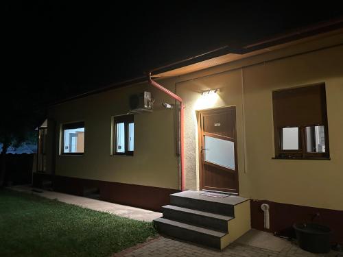 a building with stairs leading to a door at night at Airport Confort House in Otopeni