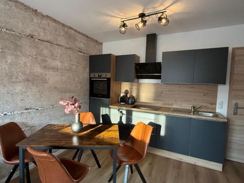 a kitchen with a table and chairs and a kitchen with a sink at Kamp 27 in Bebertal Zwei