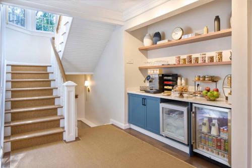 a kitchen with a staircase and a counter with food at The Sagaponack in Sagaponack