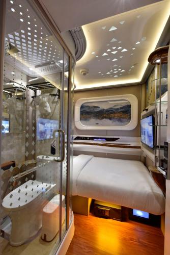 a small room with a bed and a shower at Bahrain Airport Hotel Airside Hotel for Transiting and Departing Passengers only in Muharraq