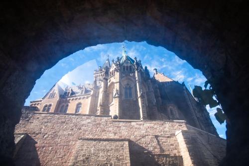 a view of a building through a stone archway at Ferienwohnungen Traumschloss in Wernigerode