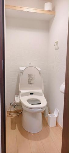 a bathroom with a toilet with the lid up at Sea Bloom Hotel in Dejimamachi