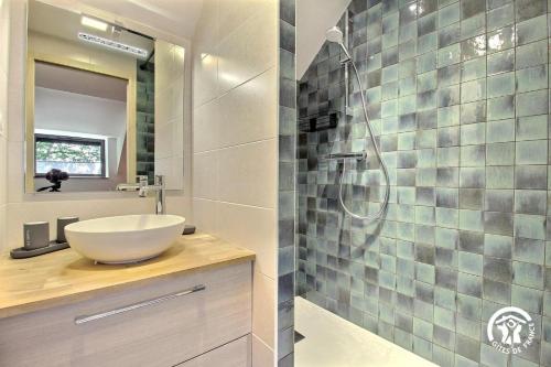 a bathroom with a sink and a glass shower at Les hortensias in Sulniac