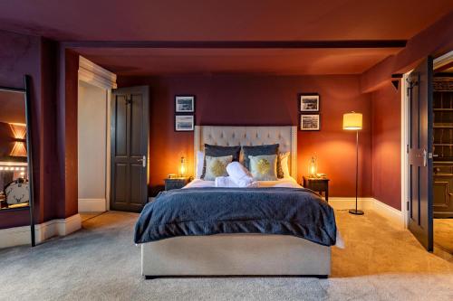 a bedroom with a large bed with orange walls at The Boat House Luxury Apartments Scarborough in Scarborough
