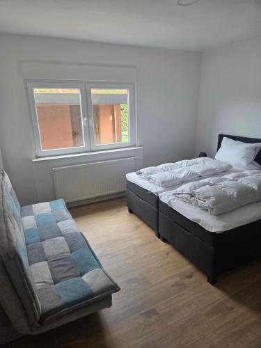 una camera da letto con un letto e una sedia di Haus Sonnenschein a Dornum