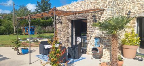 a stone building with a porch with a plant at Villa Lailléa in Laillé