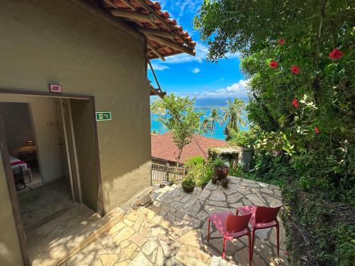 a patio with two chairs and a house at Hotel Boutique Ananas in Ilhabela
