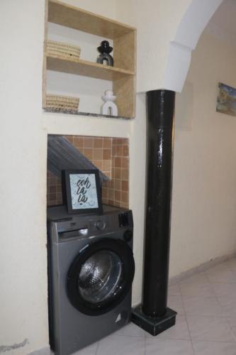 a washing machine in a room with a fireplace at Appartement Imi-Ouaddar 2 in Imi Ouaddar