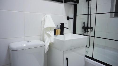 Un baño blanco con lavabo e inodoro. en ADAIA GUEST Apartments, en Johannesburgo