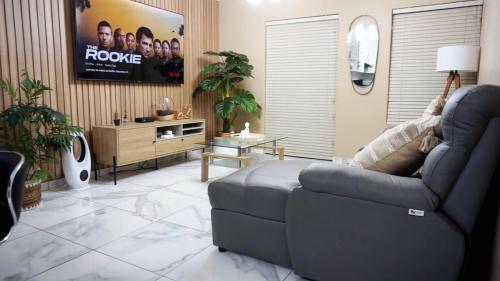 Una sala de estar con un sofá y un televisor de pantalla plana. en ADAIA GUEST Apartments, en Johannesburgo