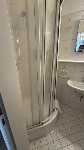 a bathroom with a shower with a toilet and a sink at Pension Am Burgtor in Lübeck