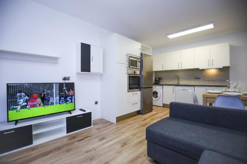 a living room with a couch and a tv and a kitchen at FORMENTOR Apartment in Salou