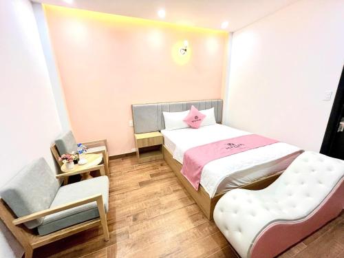 a small bedroom with a bed and a chair at New Pearl Hotel HCM in Ho Chi Minh City