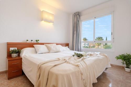 a bedroom with a large bed and a window at Residencial LOS JUNCOS III La Pineda in La Pineda