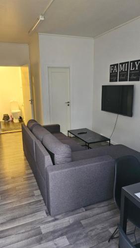 un soggiorno con divano e TV a schermo piatto di TromsøApartment Silent area with free parking I have caravan for rent same place, 4 people a Tromsø