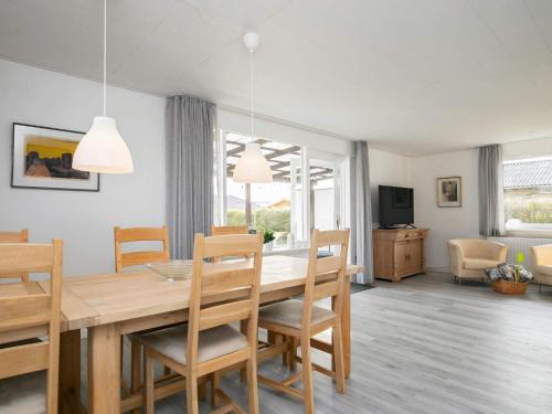 Un comedor y una sala de estar con mesa y sillas. en Spacious Holiday Home On A Large Plot, With Space To Play, en Ålbæk