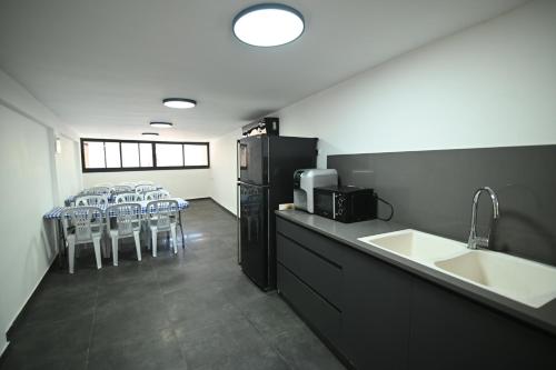 a room with a kitchen with a refrigerator and chairs at Puy Castele Hotel Tiberias in Tiberias