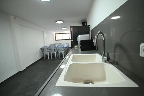 a white sink in a room with tables and chairs at Puy Castele Hotel Tiberias in Tiberias