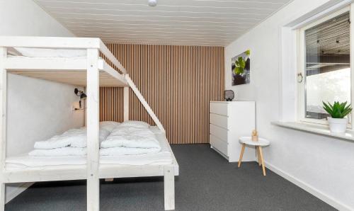 una camera con un letto a castello bianco e una finestra di Holiday Home With Hot Tub And Offers Many Activities! a Debel