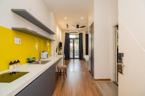 a kitchen with a counter and a yellow wall at Sơn Trà Homestay in Da Nang
