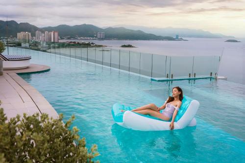 a woman and a child riding on a raft in the water at Coastal Charm Panorama Bayview in Nha Trang