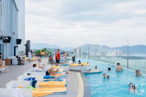 a pool on the roof of a building with people in the water at Coastal Charm Panorama Bayview in Nha Trang