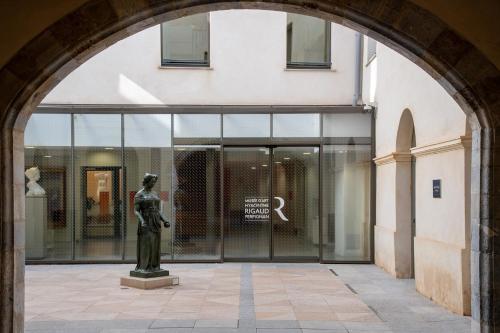 an archway with a statue in front of a building at ibis budget Perpignan Centre Rénové en 2025 in Perpignan