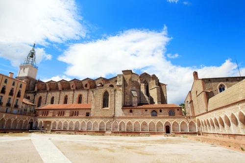 an old building with a tower in the background at ibis budget Perpignan Centre Rénové en 2025 in Perpignan