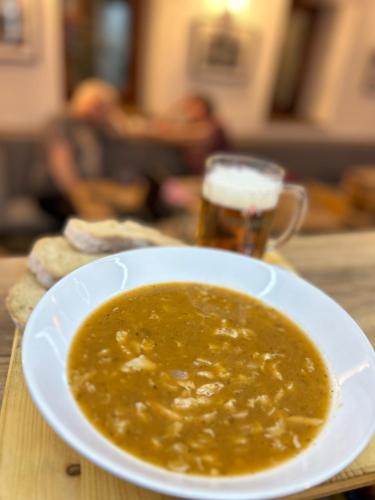 a bowl of soup and a glass of beer on a table at Penzion Aurelia Donovaly in Donovaly