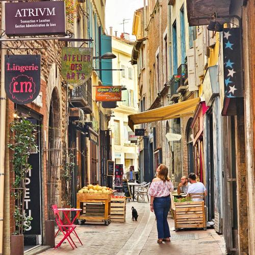 a woman walking down a street in an alley at ibis budget Perpignan Centre Rénové en 2025 in Perpignan