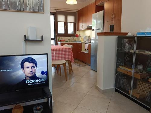 a living room with a tv and a kitchen at Forest Breeze-1 - JM Rentals in Stení Dhírfios