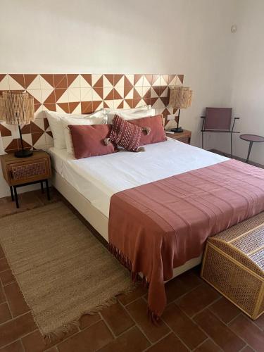 a bedroom with a large bed with pillows on it at Rustic House with 2 Pools in a Monastery in Tavira