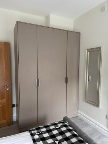 a bedroom with white cabinets and a checkered floor at Unit 3 Modern Self Contained Apartment in Cobh