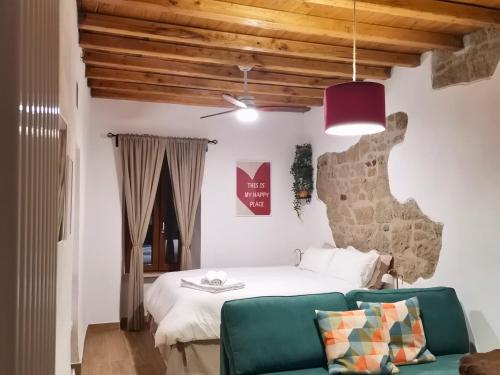 a bedroom with a bed and a green couch at La Casina di Rosina in Sacrofano