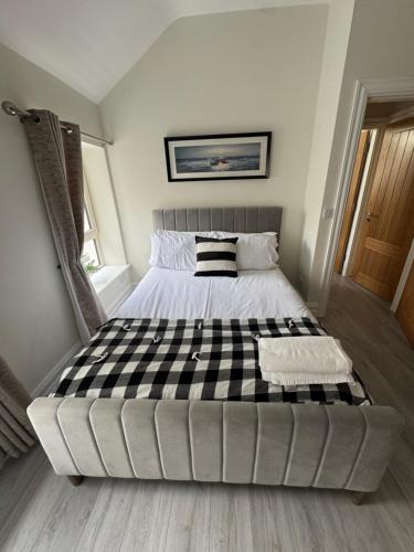 a large bed with a checkered mattress in a room at Unit 3 Modern Self Contained Apartment in Cobh