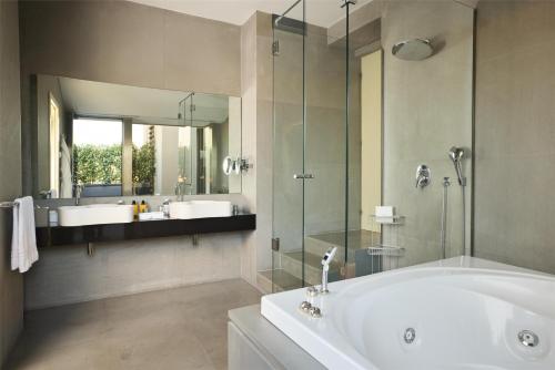 a bathroom with a tub and two sinks and a mirror at Anantara Palazzo Naiadi Rome Hotel - A Leading Hotel of the World in Rome