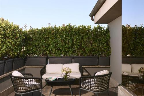 a patio with chairs and a table with flowers on it at Anantara Palazzo Naiadi Rome Hotel - A Leading Hotel of the World in Rome
