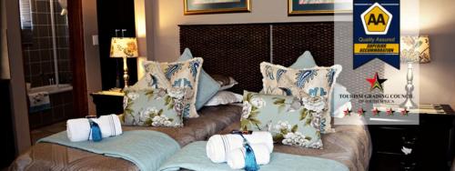 a bedroom with a bed with towels on it at De Stallen Guest Villas and Golf Course in Bloemfontein