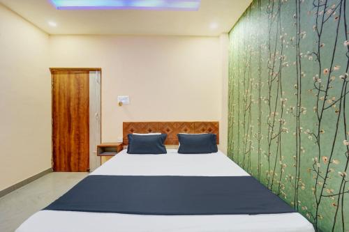 a bedroom with a bed and a green wall at Hotel O UDAAN BANQUET & FILMS in Khagaul