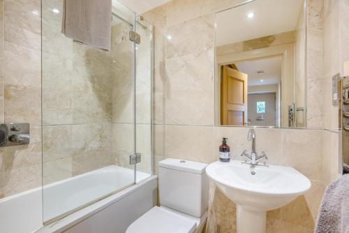 a bathroom with a sink and a toilet and a bath tub at 2 Bed in Langham oc-l33117 in Langham