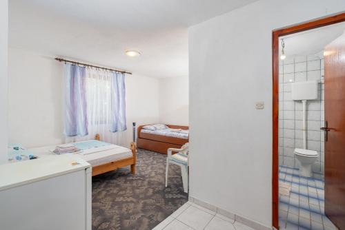 a room with a bathroom with a bed and a toilet at Rooms Mat in Vir