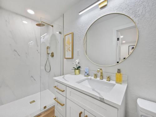a white bathroom with a sink and a mirror at Vacation Villa in Tampa 17 Guest in Tampa
