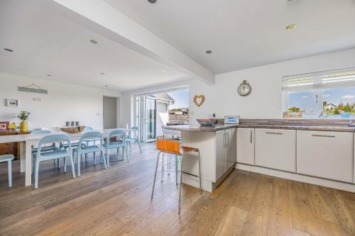 eine Küche und ein Esszimmer mit Tisch und Stühlen in der Unterkunft Sundowner - West Wittering in East Wittering