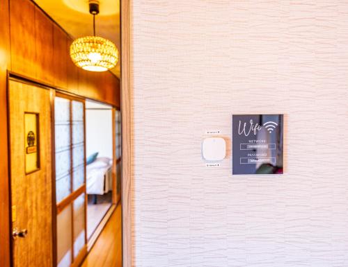 a hallway with a wall with a sign on it at Lax奈良 奈良観光に便利な和モダン古民家 最大12名 グループや家族旅行に最適 in Nara