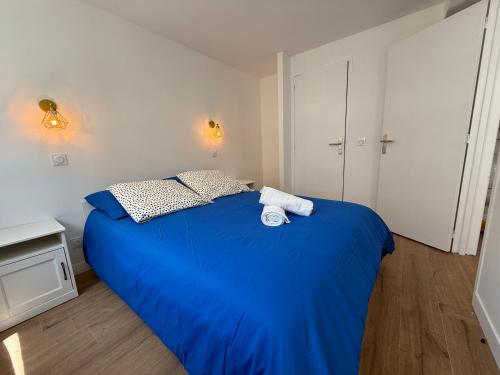 une chambre avec un lit bleu avec deux serviettes dessus dans l'établissement Chez Maria, à Lourdes