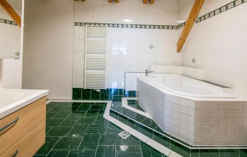 a bathroom with a tub and a green floor at 2 Bedroom Lovely Apartment In Stainz in Stainz