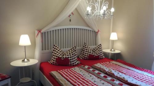 a bedroom with a bed with a red blanket and pillows at Märchengarten Hänsel und Gretel in Putbus