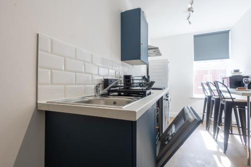 a kitchen with a sink and a table with chairs at St James Court Hotel in Derby