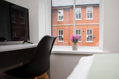a black chair sitting in front of a window at St James Court Hotel in Derby
