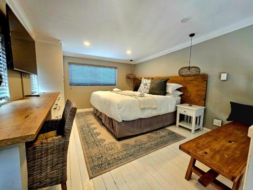 a bedroom with a bed and a desk and a table at 9 on Winkle Boutique Guesthouse in Cape Town